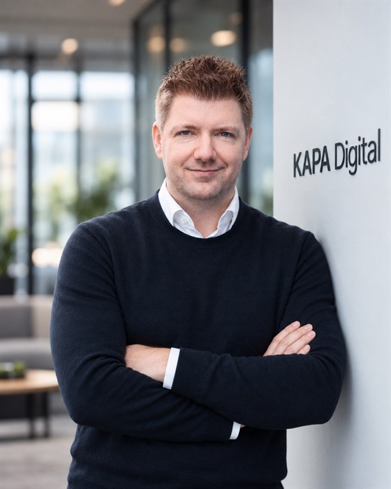 Sebastian Linges, Gründer von KAPA Digital, im Foyer neben dem Firmenschriftzug